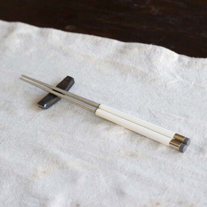 White Korean chopsticks on a metal chopstick rest