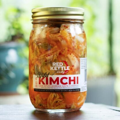 A jar of mild kimchi from Red Kettle Kimchi. It is a lighter orangey color than the normal spicy Classic Kimchi